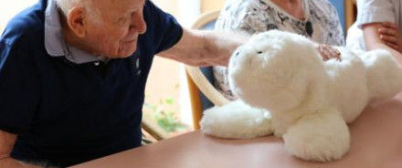 Homme âge qui caresse une peluche 